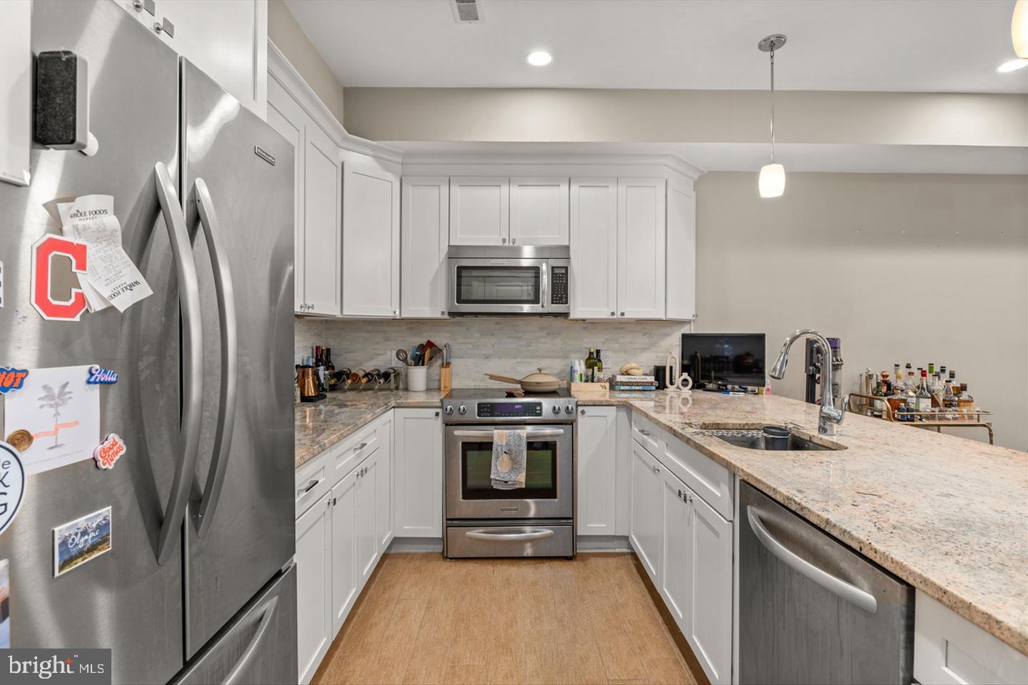 1431 Corcoran Street Northwest, Unit 1 Washington, DC 20009 - Photo 8 of 14 a kitchen with stainless steel appliances granite countertop a stove a sink and a refrigerator