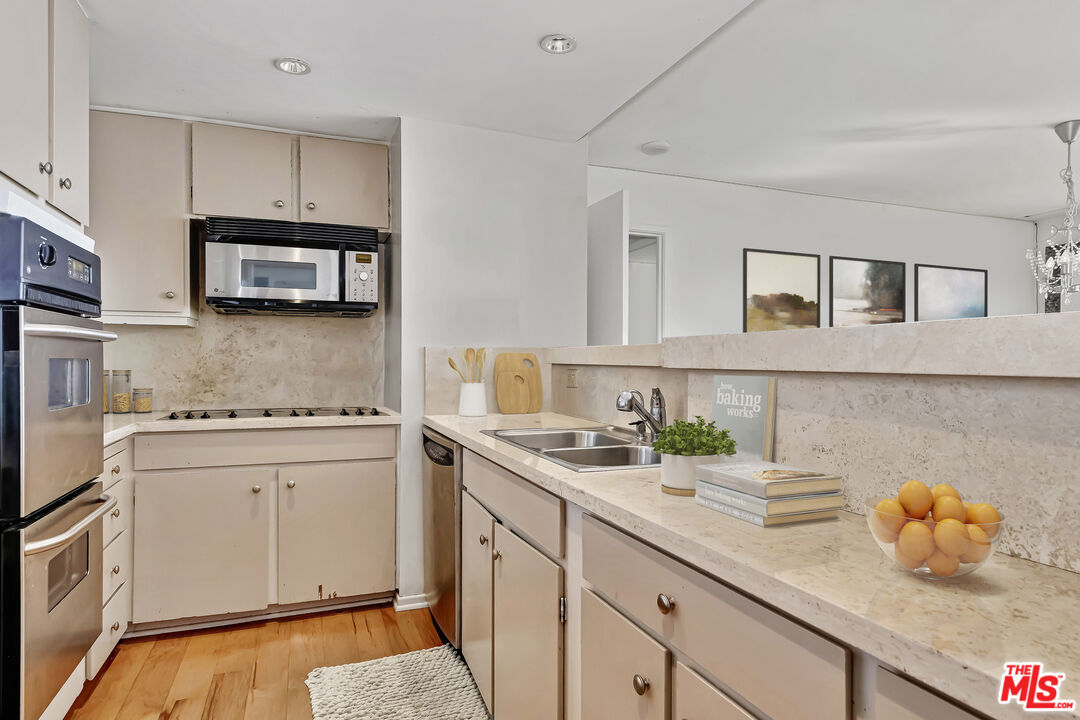 2170 Century Park East, Unit 1507 Los Angeles, CA 90067 - Photo 7 of 17 a kitchen with stainless steel appliances a stove a sink and cabinets