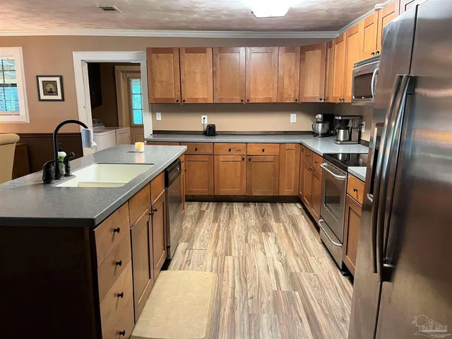 a kitchen with granite countertop a sink stainless steel appliances and cabinets