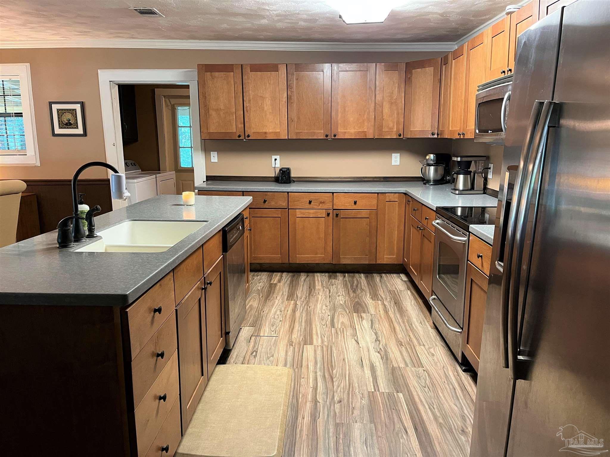 77 Hill Street Atmore, AL 36502 - Photo 12 of 30 a kitchen with granite countertop a sink stainless steel appliances and cabinets