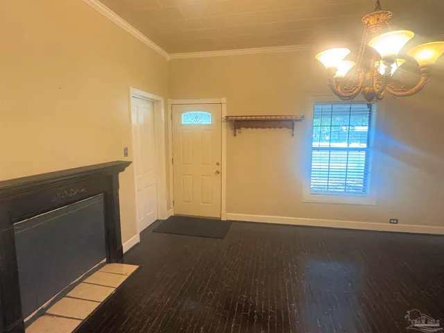 an empty room with wooden floor mirror and windows