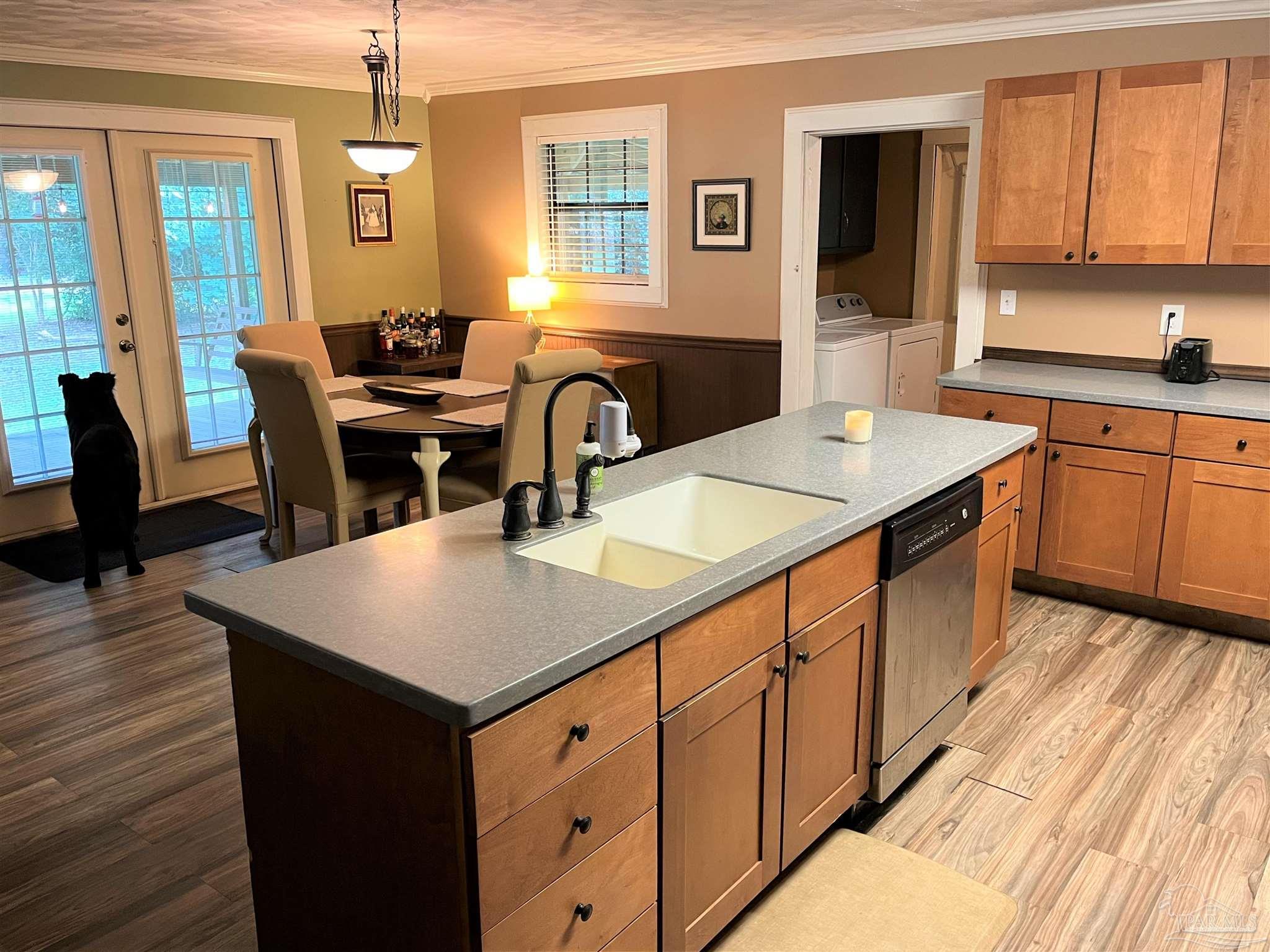 77 Hill Street Atmore, AL 36502 - Photo 8 of 30 a kitchen with a stove a sink a dining table and chairs