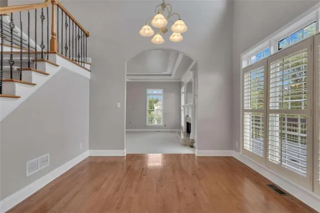 a view of an empty room with a chandelier fan