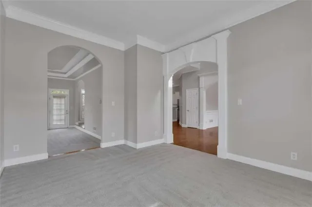 a view of an empty room with wooden floor fireplace and a window