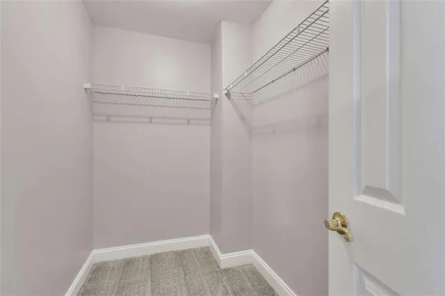 a sign that is sitting on a brick wall with plants and large trees