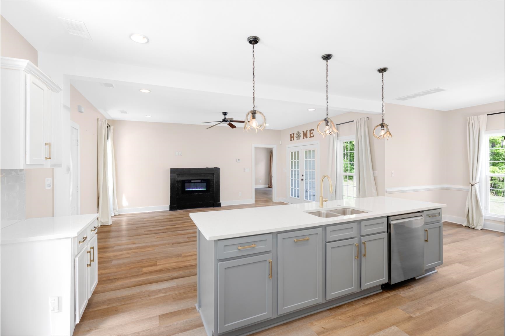 5702 Spring Lake Road Memphis, TN 38135 - Photo 17 of 40 Kitchen island with light gray cabinetry, white countertops, and a dual-basin sink with a gold-tone faucet