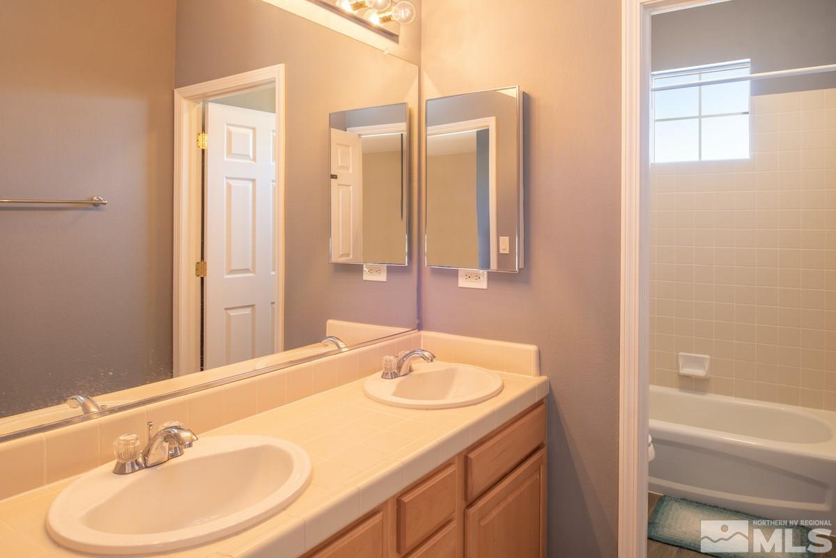 9917 Rio Bravo Drive Reno, NV 89521 - Photo 16 of 36 a bathroom with a granite countertop sink and a mirror