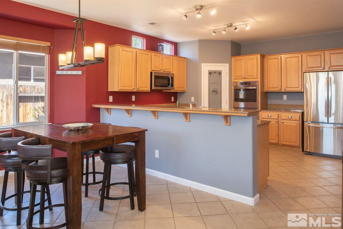9917 Rio Bravo Drive Reno, NV 89521 - Photo 7 of 36 a kitchen with stainless steel appliances granite countertop a sink counter space and a refrigerator