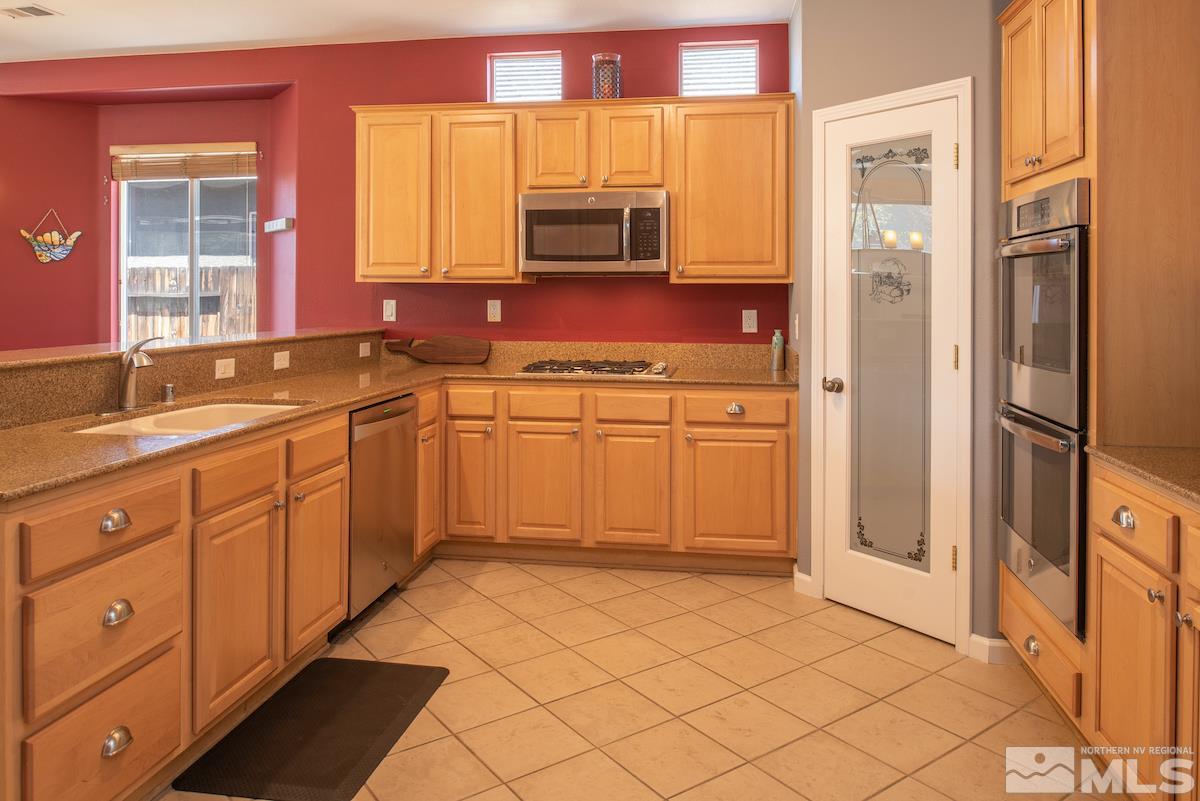 9917 Rio Bravo Drive Reno, NV 89521 - Photo 8 of 36 a kitchen with stainless steel appliances granite countertop a refrigerator and a sink