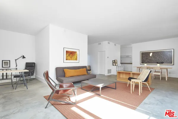 a living room with furniture a rug and a window