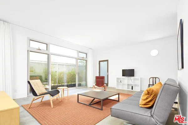 a living room with furniture and floor to ceiling windows