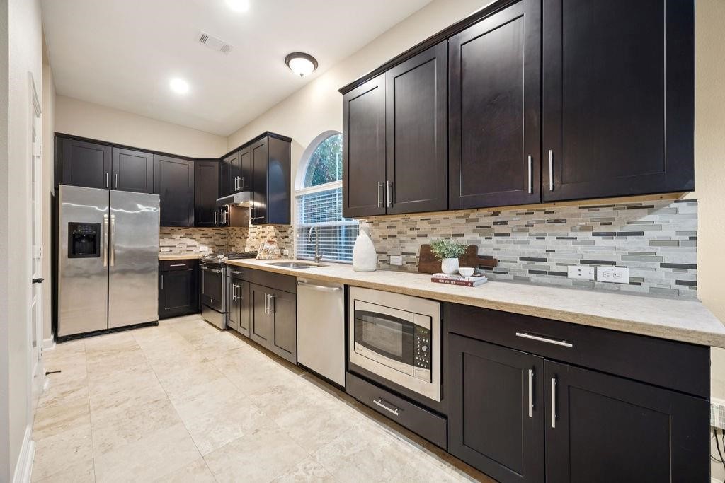 5407 Lillian Street Houston, TX 77007 - Photo 17 of 38 a kitchen with stainless steel appliances a sink stove and cabinets