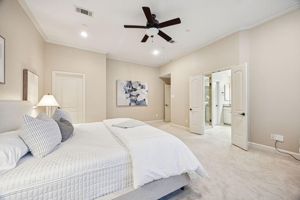 5407 Lillian Street Houston, TX 77007 - Photo 22 of 38 a spacious bedroom with a bed and a chandelier