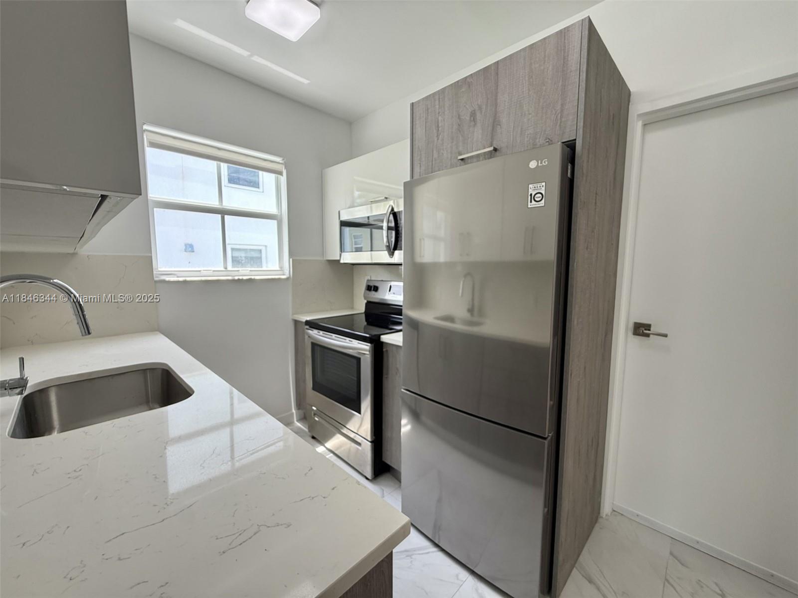 1552 Euclid Avenue, Unit 3 Miami Beach, FL 33139 - Photo 3 of 13 a kitchen with a refrigerator and a sink