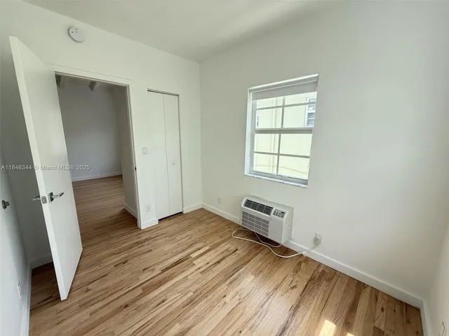 an empty room with wooden floor and a window