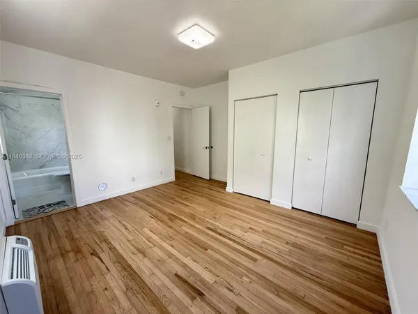 a view of a room with wooden floor and brick wall