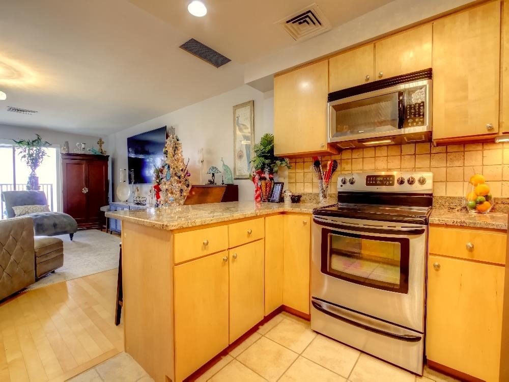655 Riverside Drive, Unit 805A Memphis, TN 38103 - Photo 9 of 25 a kitchen with stainless steel appliances a stove sink and cabinets