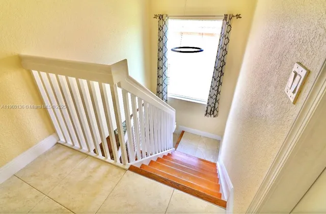 a view of staircase with white walls and a window