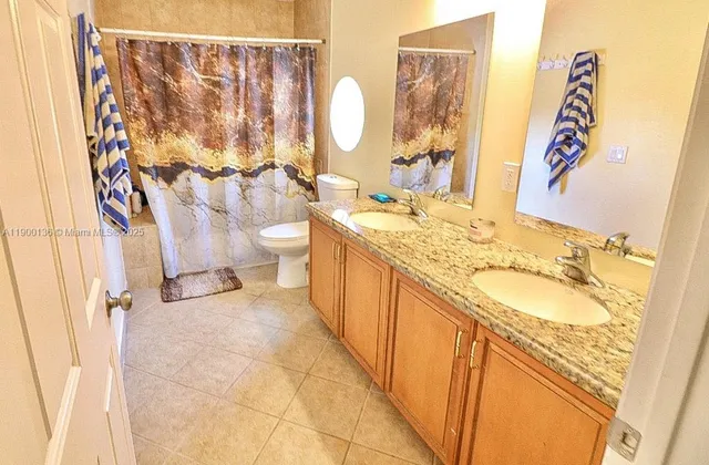 a bathroom with a granite countertop sink toilet and a bathtub