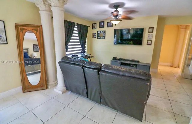 a living room with furniture a flat screen tv and a window