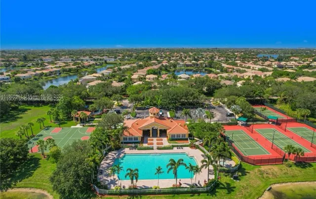 an aerial view of residential houses with outdoor space and trees