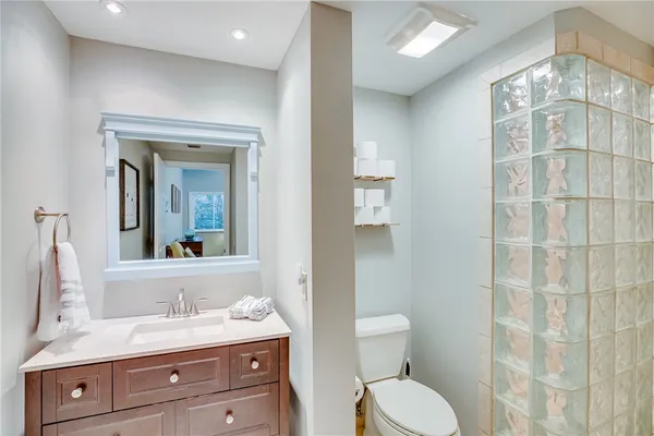 a bathroom with a granite countertop toilet sink and mirror