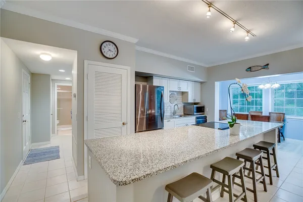 a kitchen with granite countertop a table and chairs in it
