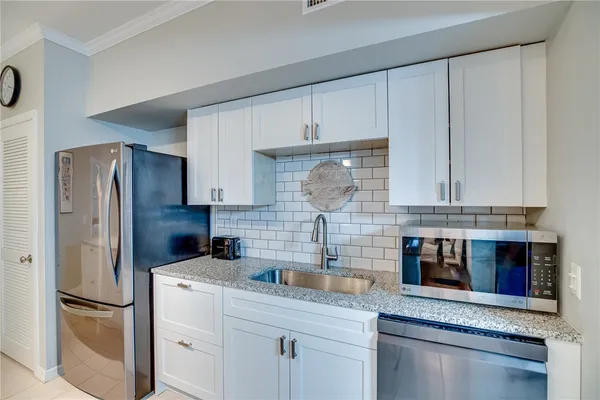 a kitchen with stainless steel appliances granite countertop a refrigerator sink and cabinets