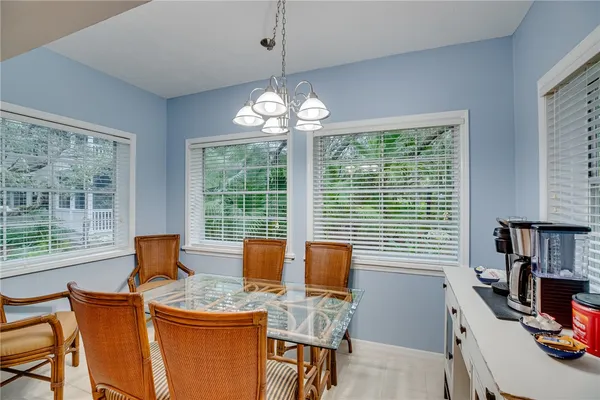 a dining room with furniture a chandelier and window