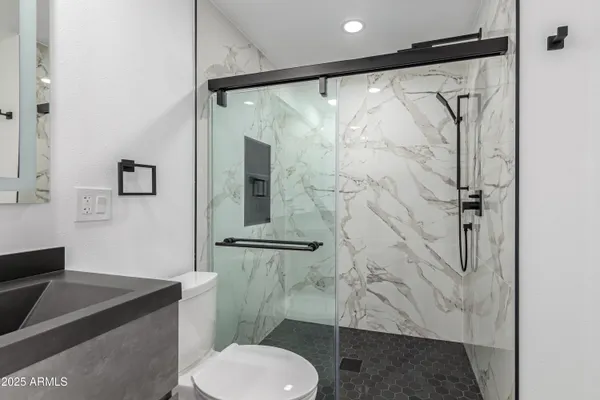 a bathroom with a granite countertop shower toilet and sink