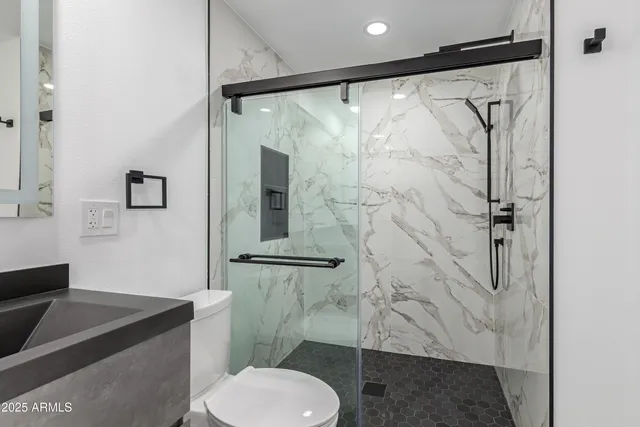 a bathroom with a granite countertop shower toilet and sink