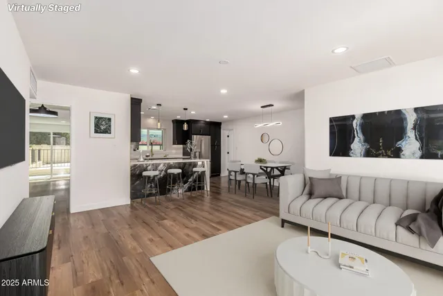 a living room with furniture and a wooden floor