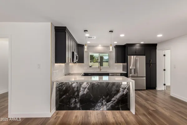a view of kitchen with refrigerator microwave and wooden floor