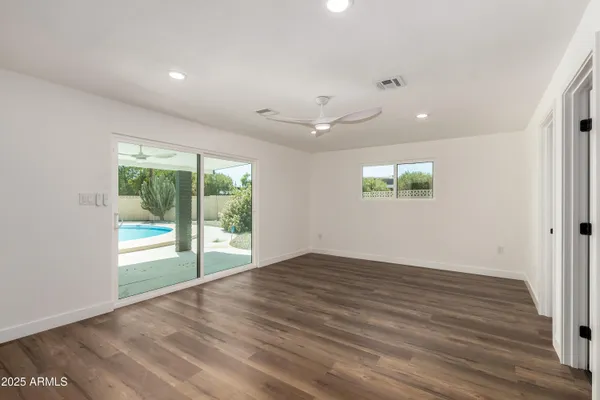 an empty room with wooden floor and windows