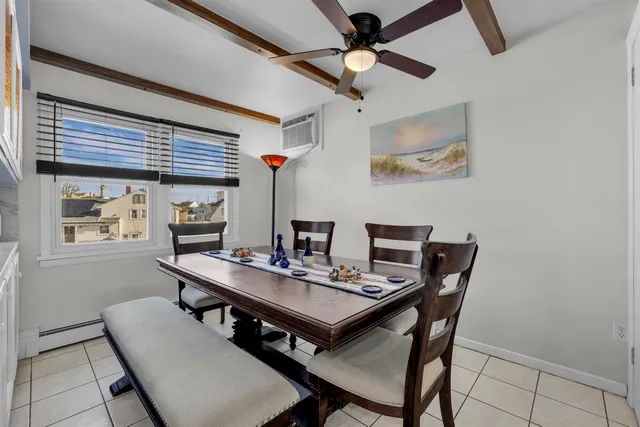 a dining room with stainless steel appliances granite countertop a table chairs and a refrigerator