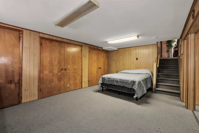 a kitchen with stainless steel appliances kitchen island granite countertop a dining table chairs refrigerator and microwave