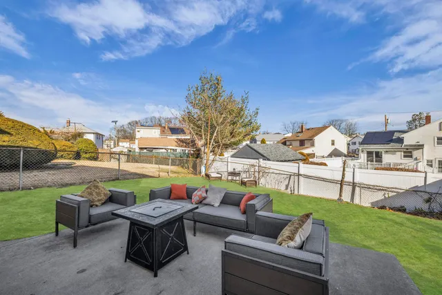 a view of a patio with couches chairs and a big yard