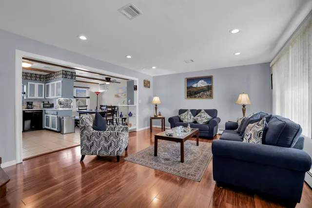 a living room with furniture a rug and a lamp