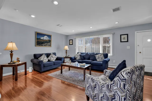 a living room with furniture and a wooden floor