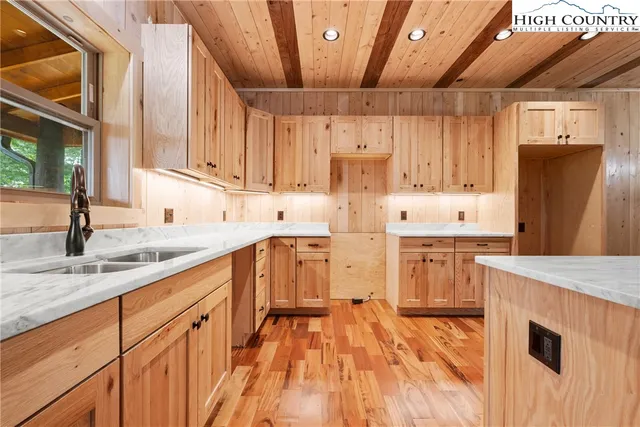 a kitchen with granite countertop a sink a counter space appliances and cabinets