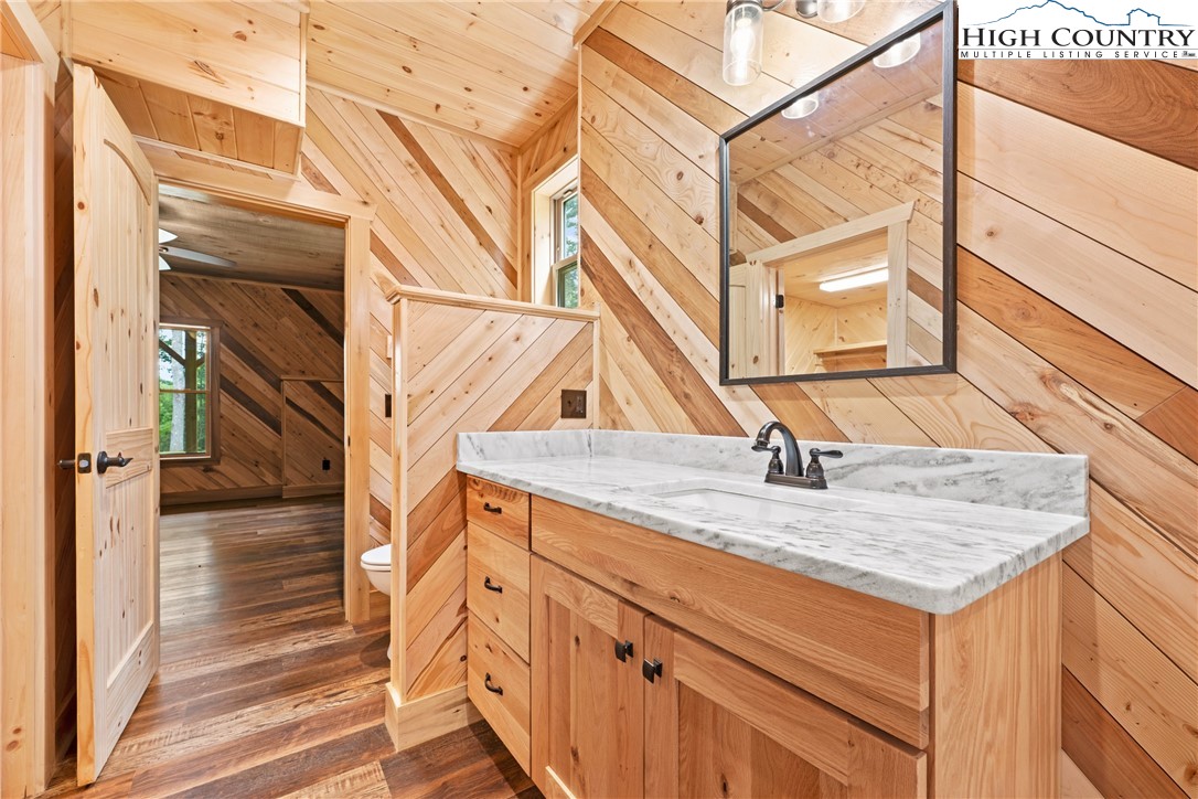 449 Hampton Ridge Road Fleetwood, NC 28626 - Photo 28 of 43 a bathroom with a granite countertop sink and a mirror