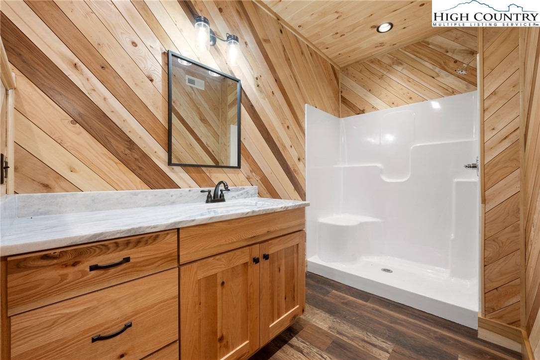449 Hampton Ridge Road Fleetwood, NC 28626 - Photo 30 of 43 a bathroom with a granite countertop sink and a shower