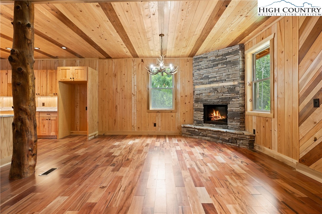 449 Hampton Ridge Road Fleetwood, NC 28626 - Photo 7 of 43 a view of an empty room with wooden floor fireplace and a window