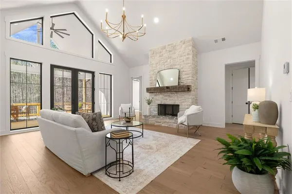 a living room with furniture kitchen view and a chandelier