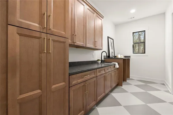 a spacious bathroom with a granite countertop sink and a mirror
