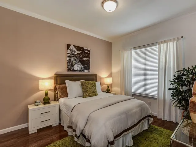 a bedroom with a bed and a potted plant