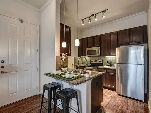 a kitchen with a refrigerator a stove a sink and a microwave