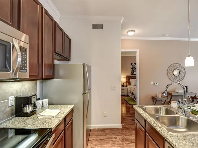 a kitchen with stainless steel appliances granite countertop a sink stove and refrigerator