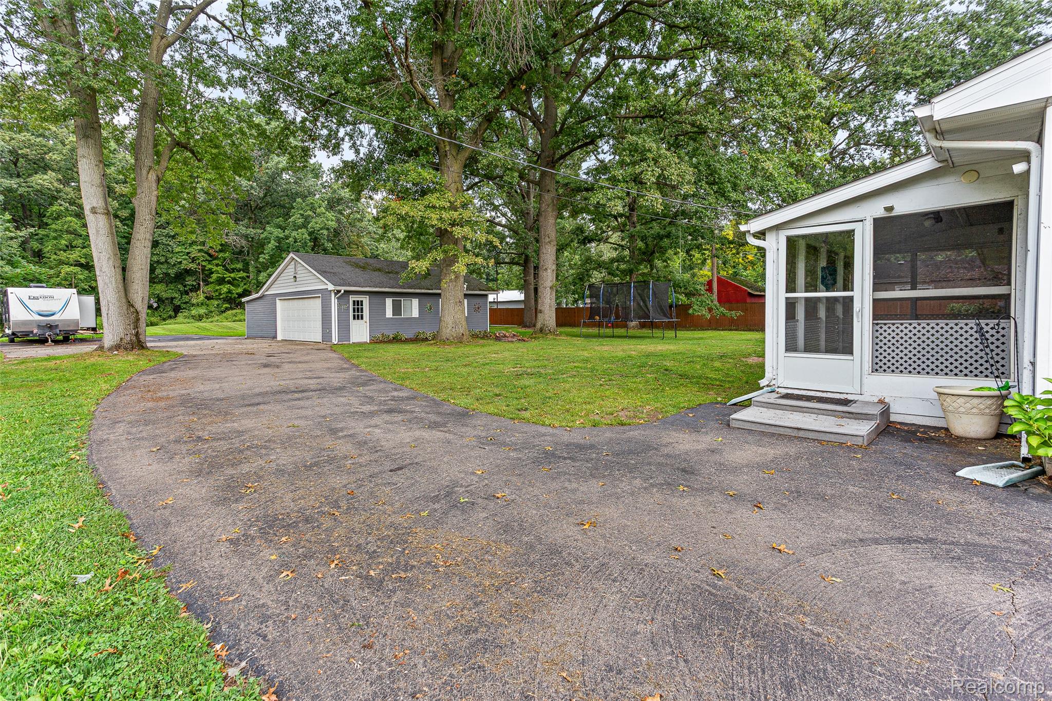 9561 Exeter Road Carleton, MI 48117 - Photo 38 of 46 Paved driveway leading to a detached garage with a white overhead door