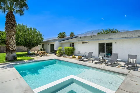 a view of a house with swimming pool and sitting area